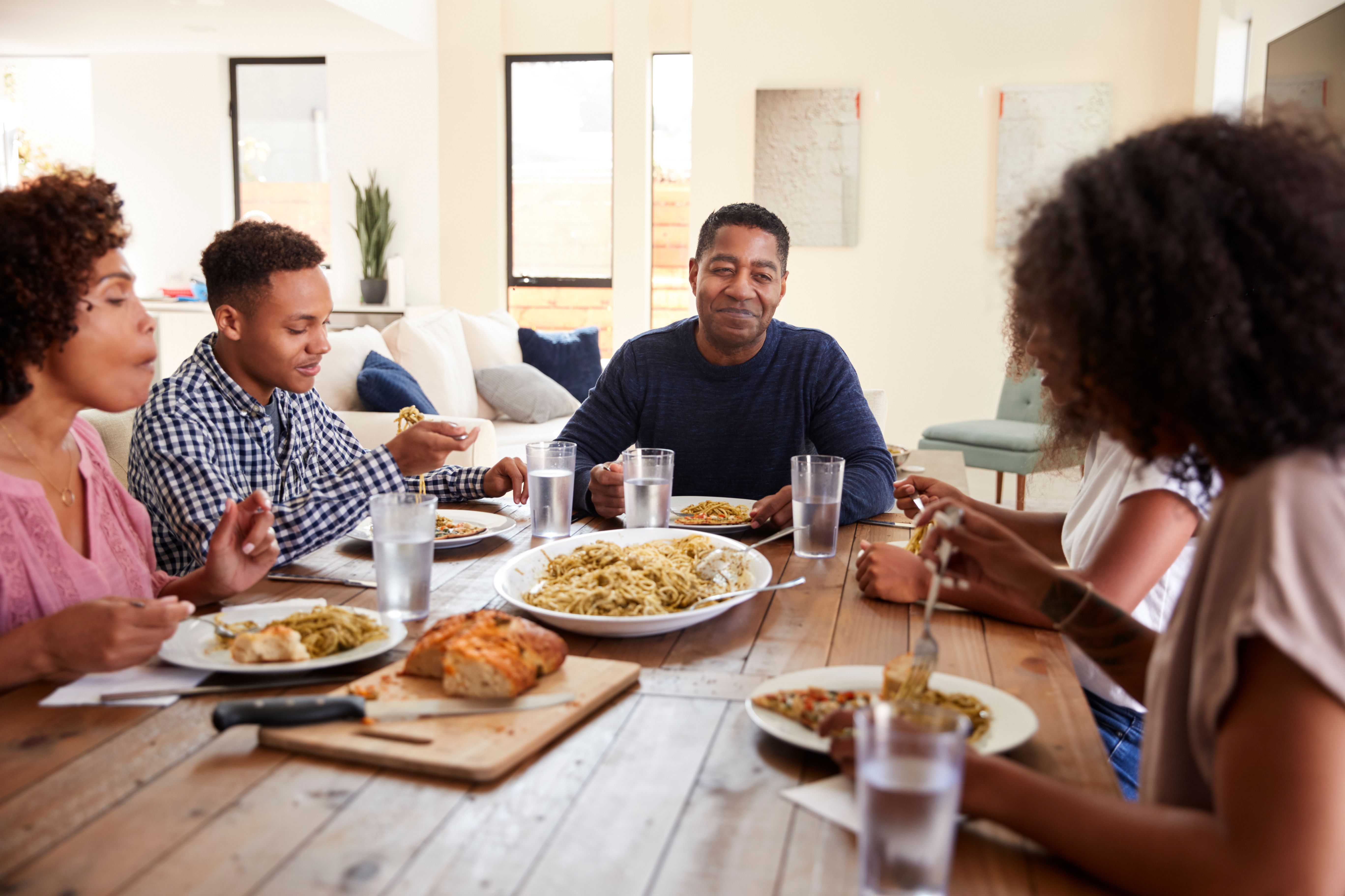 family with teenagers sitting at dinner table