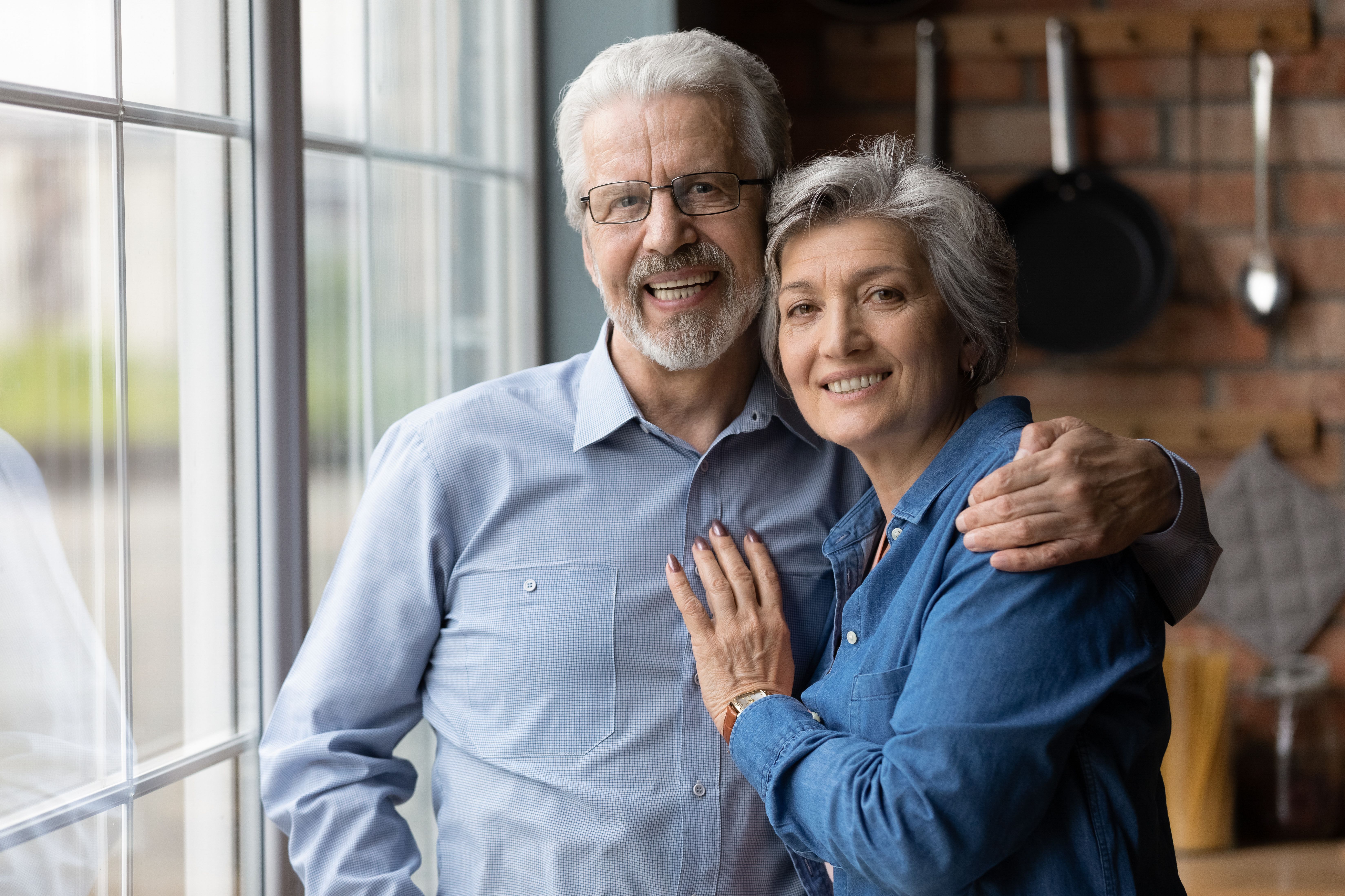 Older couple pose in kitchen