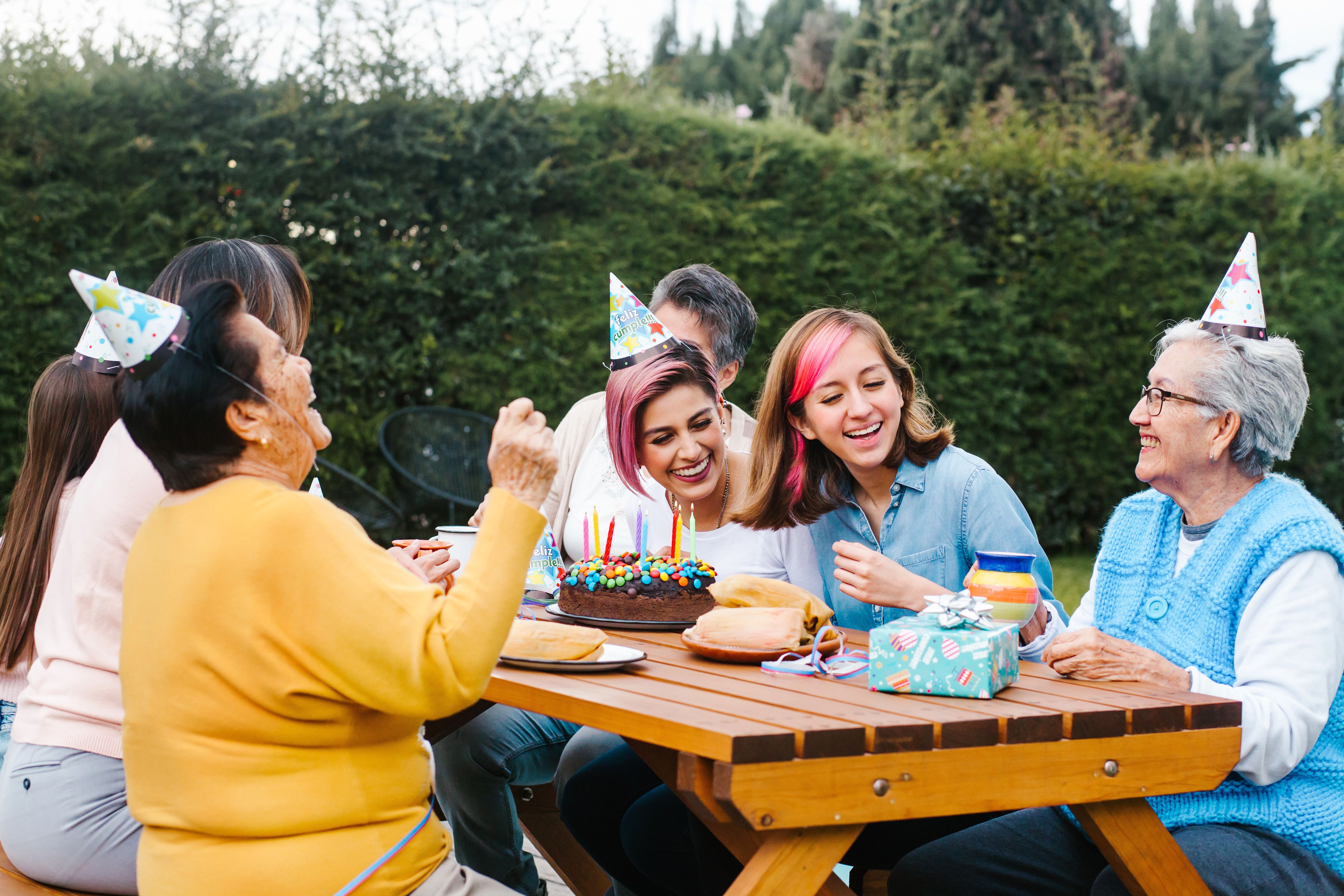 Family celebrates birthday outside at picnic table