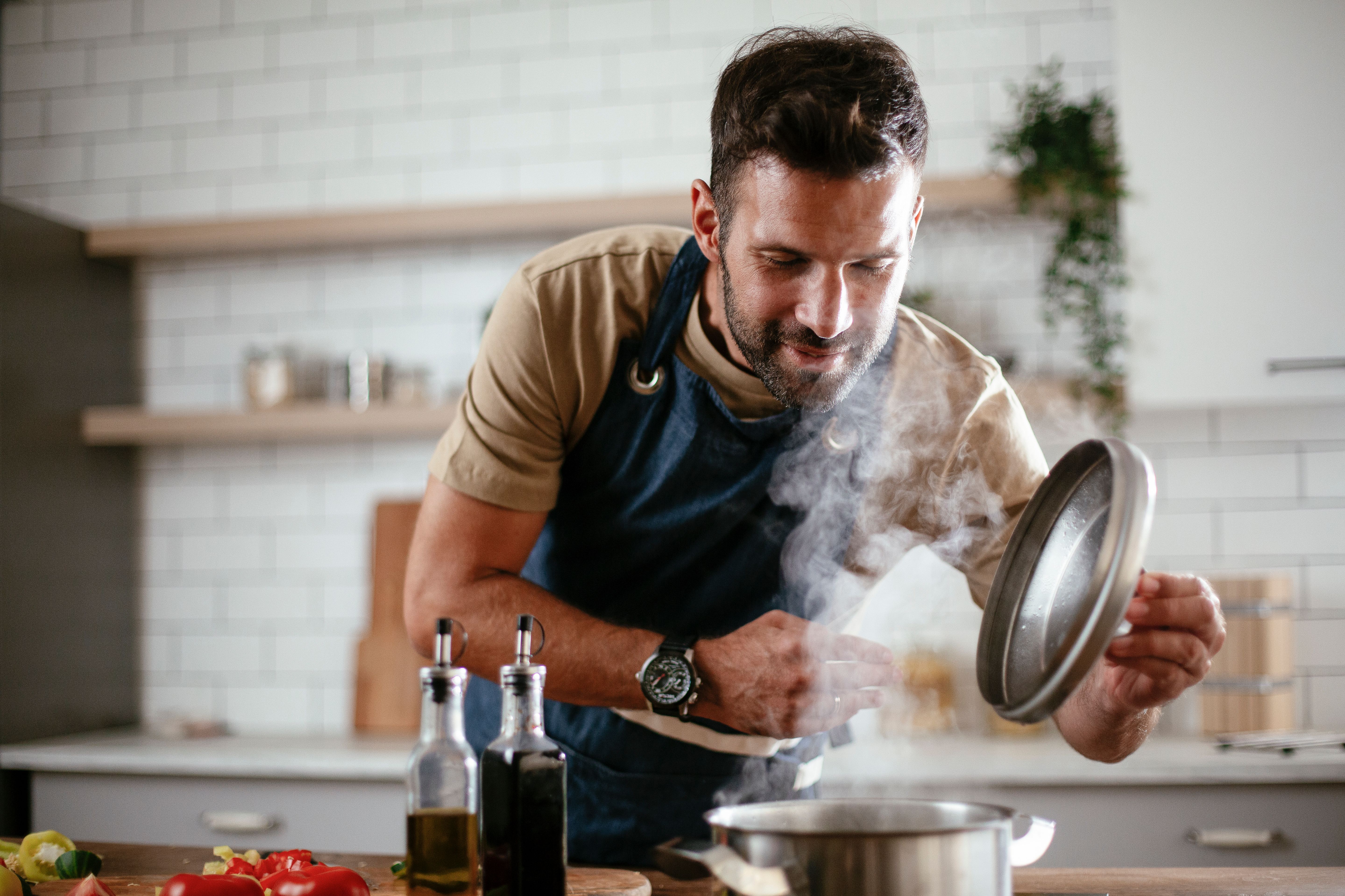 Home chef checking pot in kitchen