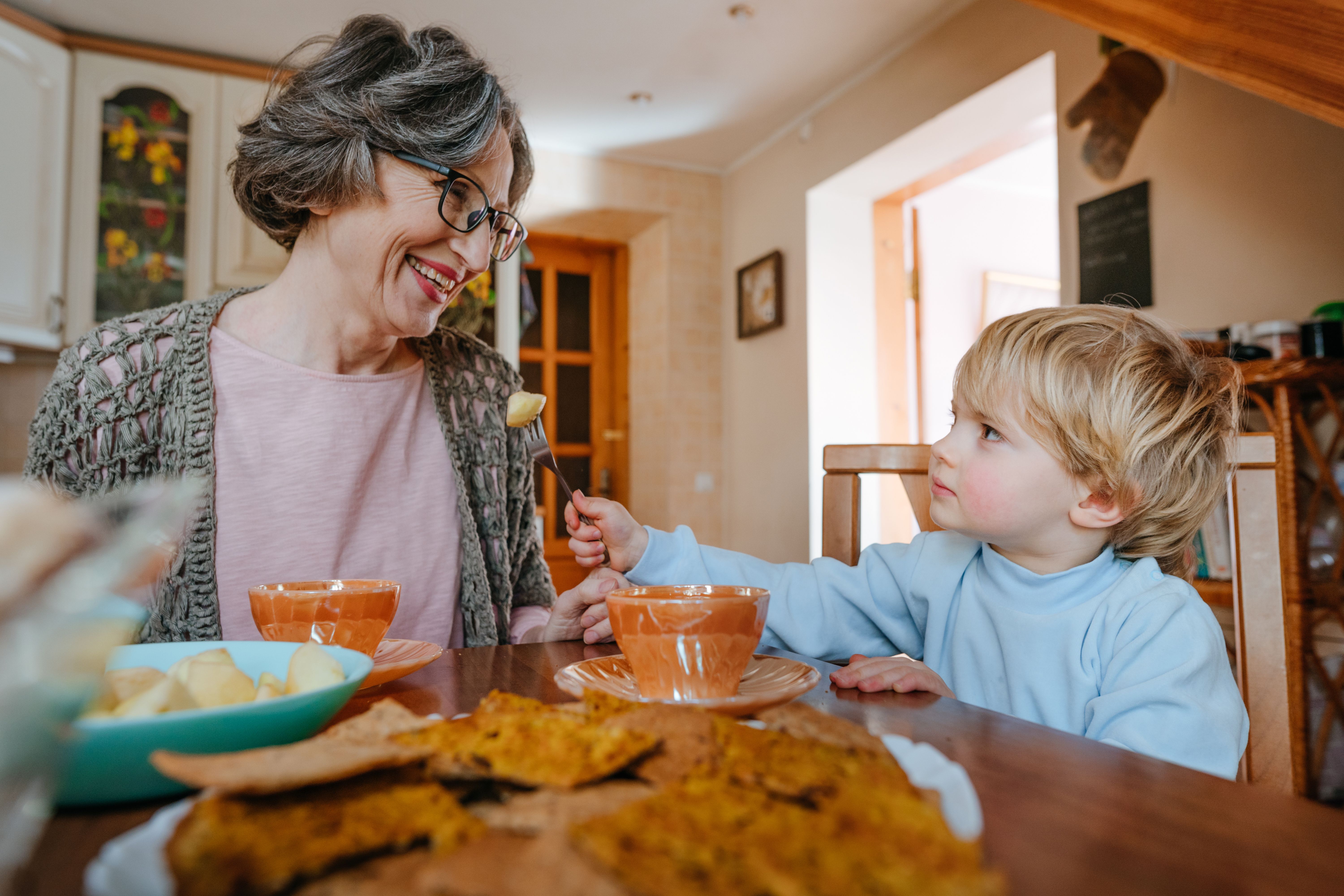 grandma with toddler eating dinner