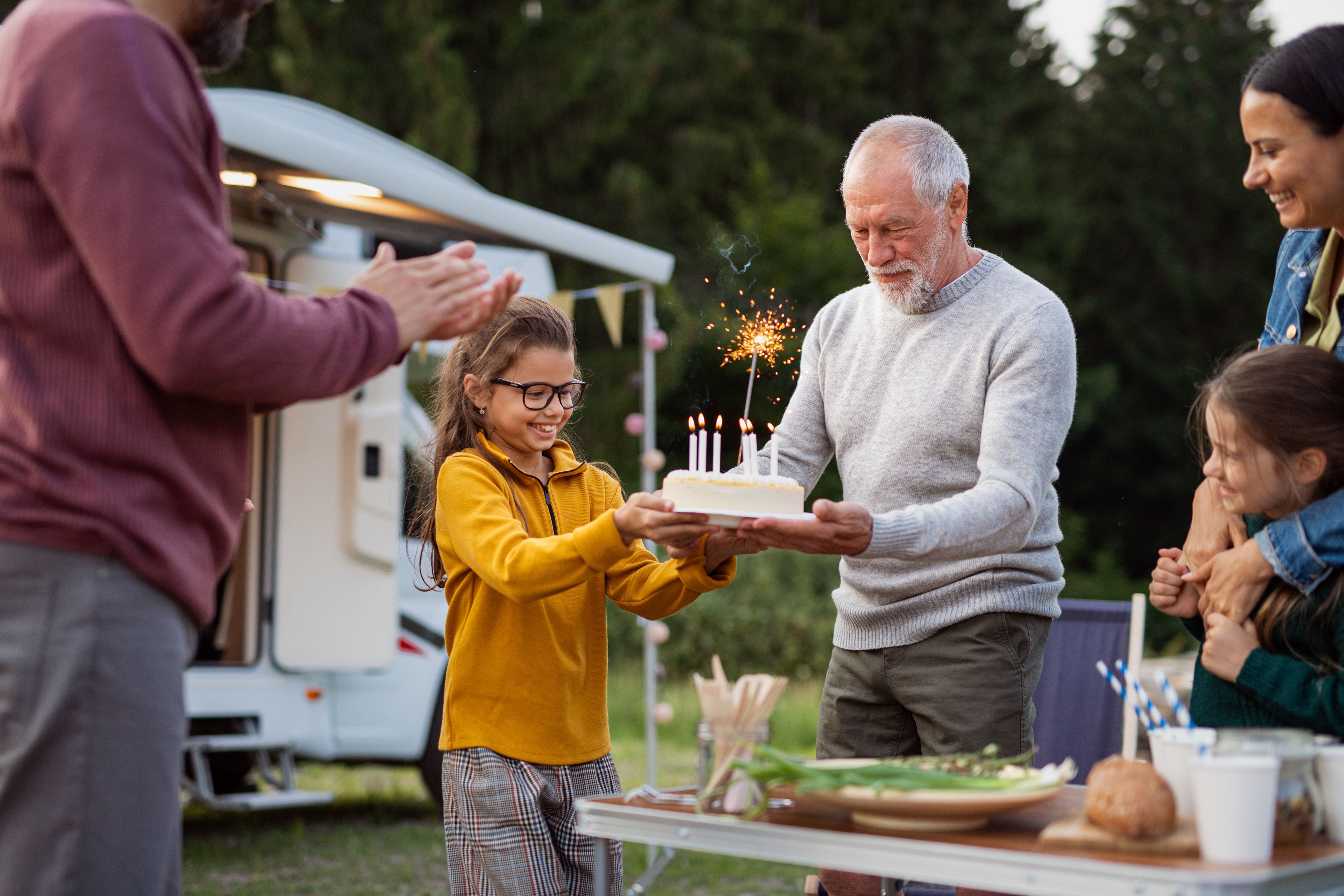 Grandpa carrying birthday cake with candles