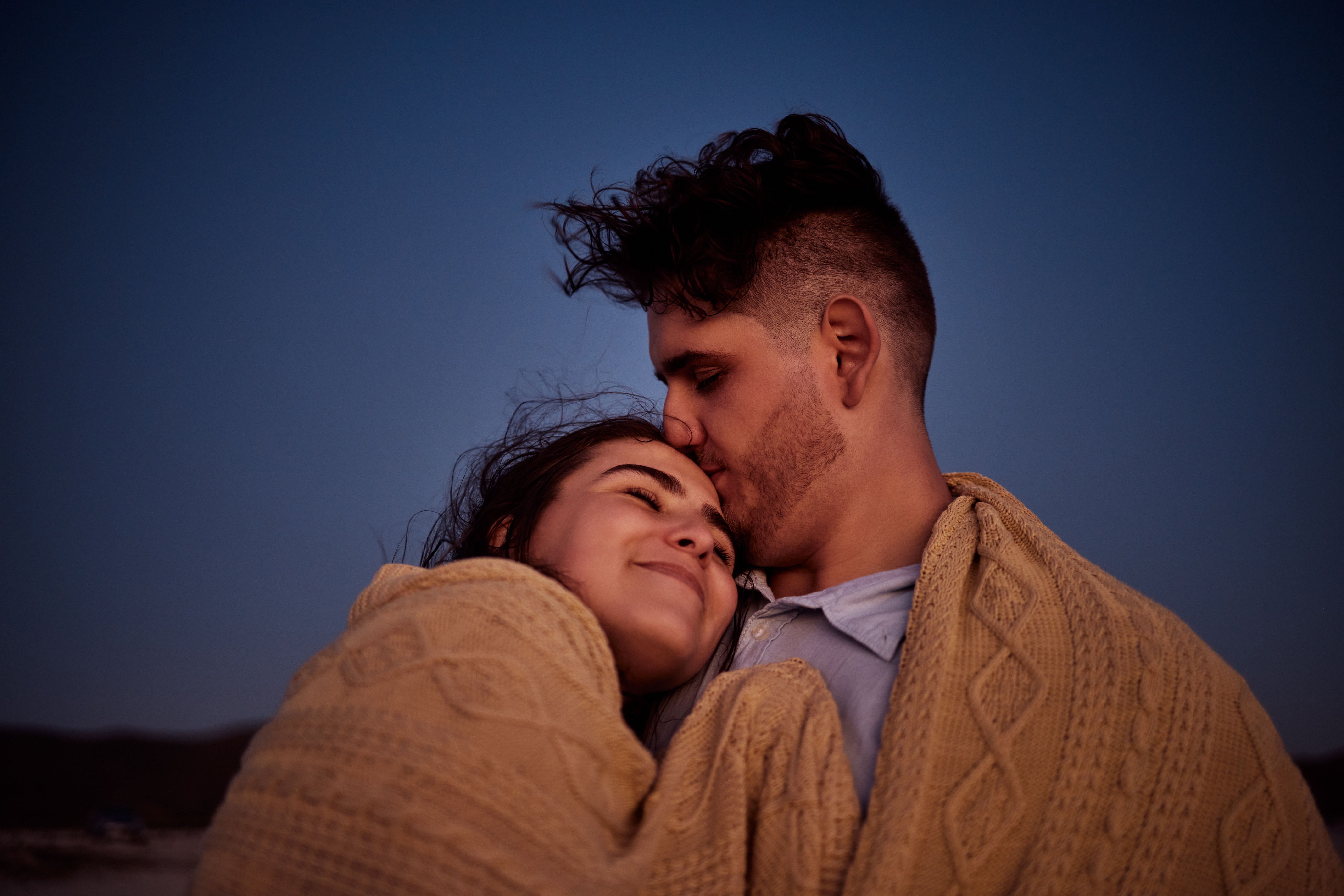 Couple stargazing wrapped in blanket