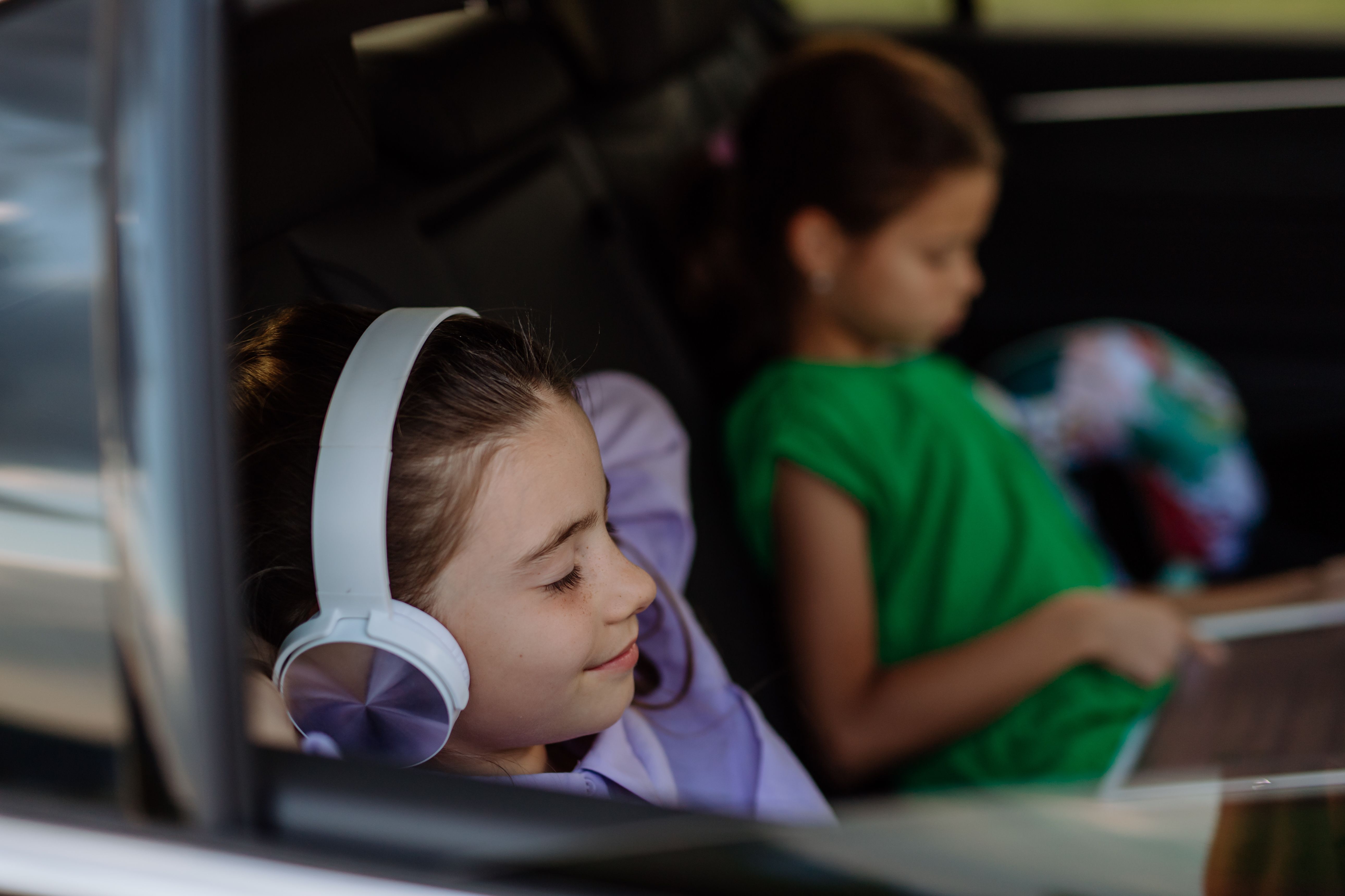 Girls listening to headphones in car