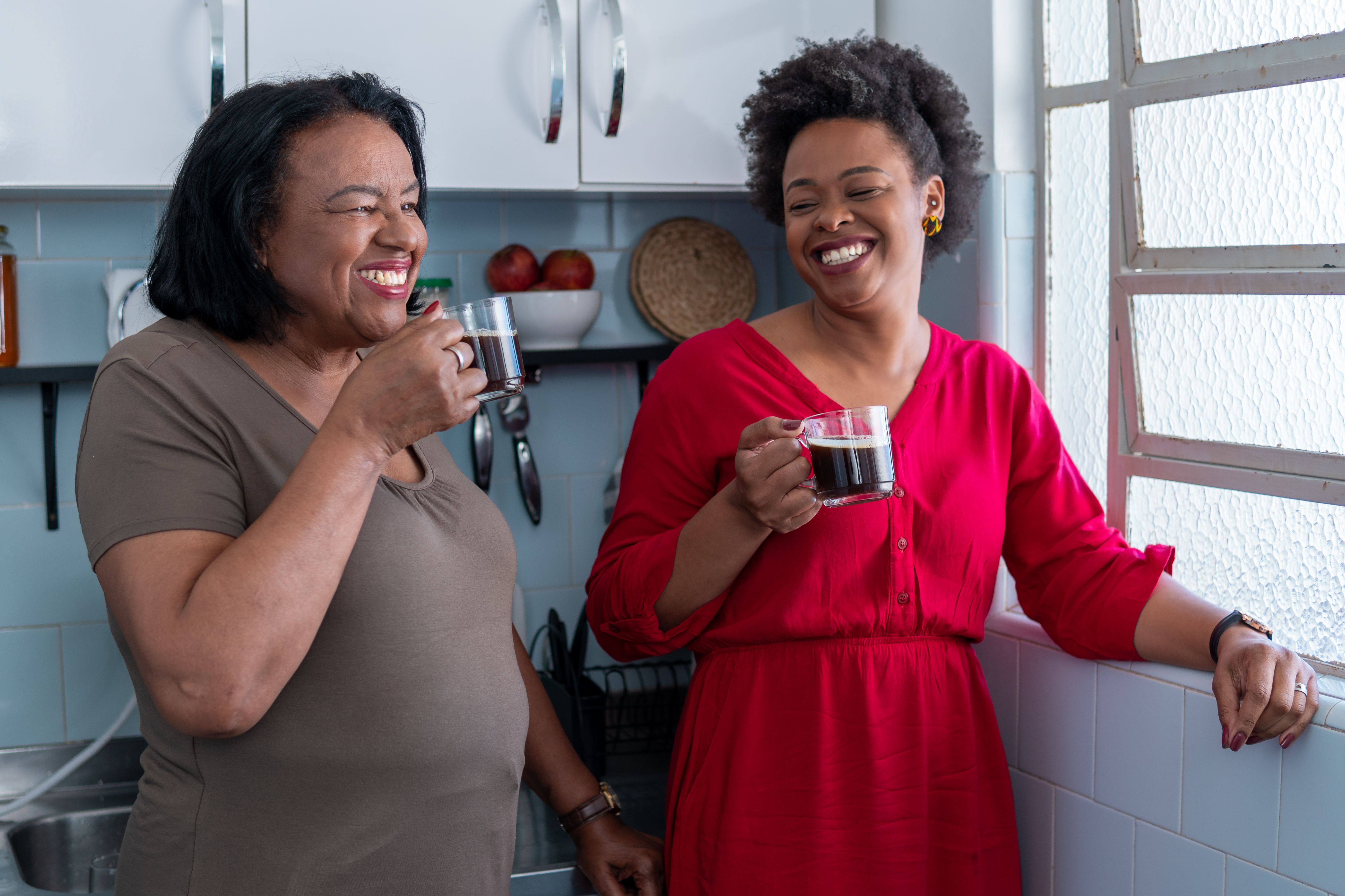 Mother and daughter drinking coffee in kitchen