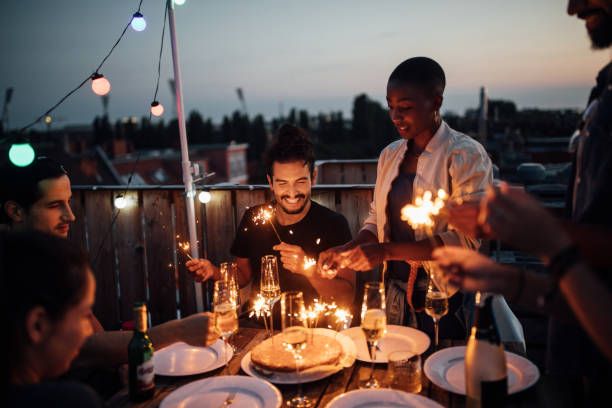 group of adult friends celebrating birthday on deck outside