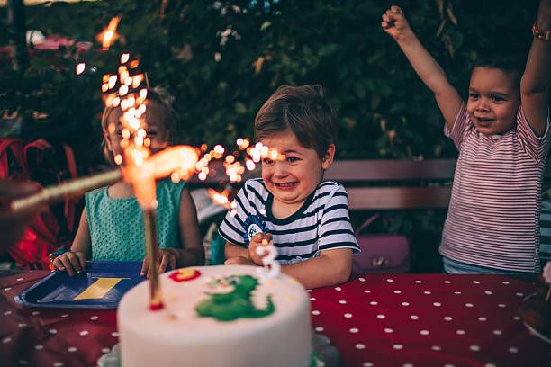 toddler boy with birthday cake outside